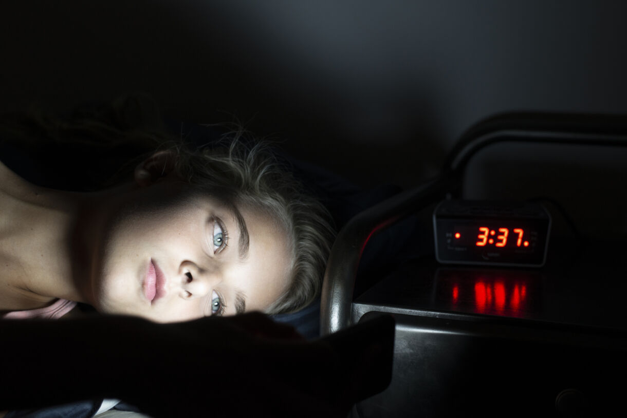 Teenage girl using smartphone at night